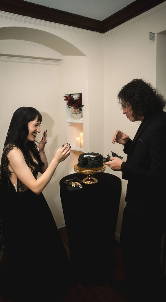 Bride and Groom eating cake in their black theme wedding