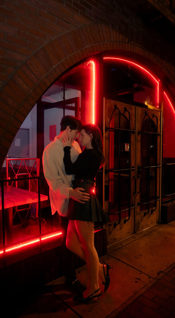 Cinematic nighttime portrait of a couple embracing in front of Tilden.