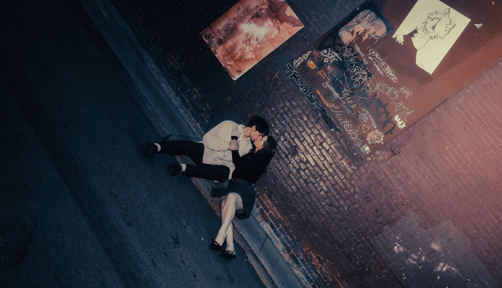 Cinematic street photo of a couple embracing under Pittsburgh street lights.
