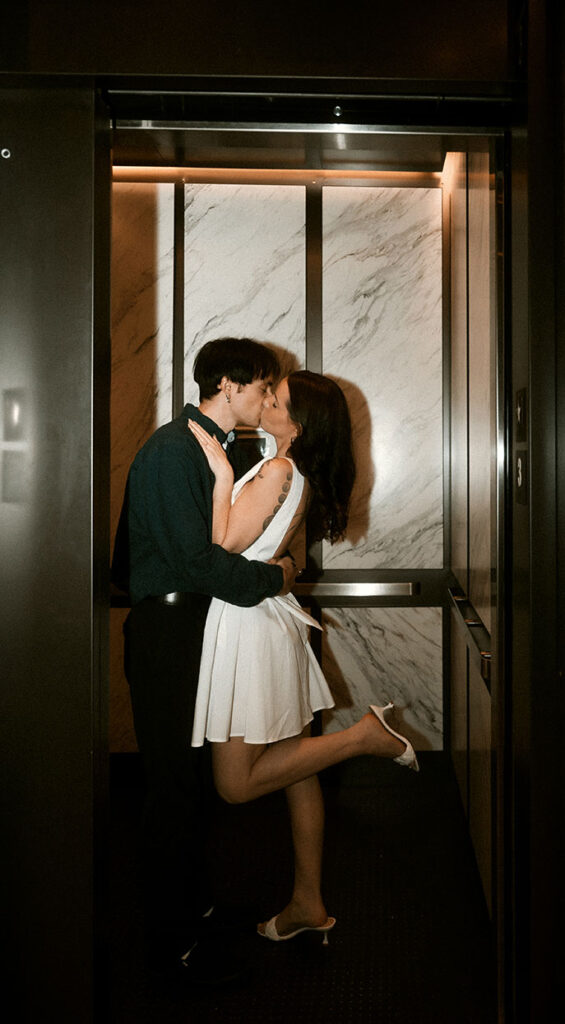 Documentary-style photo of a couple Kissing in an elevator in Downtown Pittsburgh