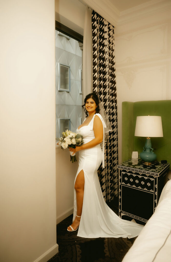 Bride getting ready in front of the window of the Kimpton Hotel in Downtown Pittsburgh