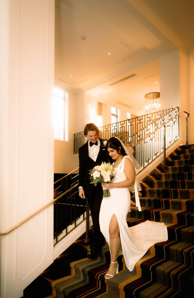 Bride and groom coming down the staircase of Kimpton Hotel Monaco before their courthouse elopement.