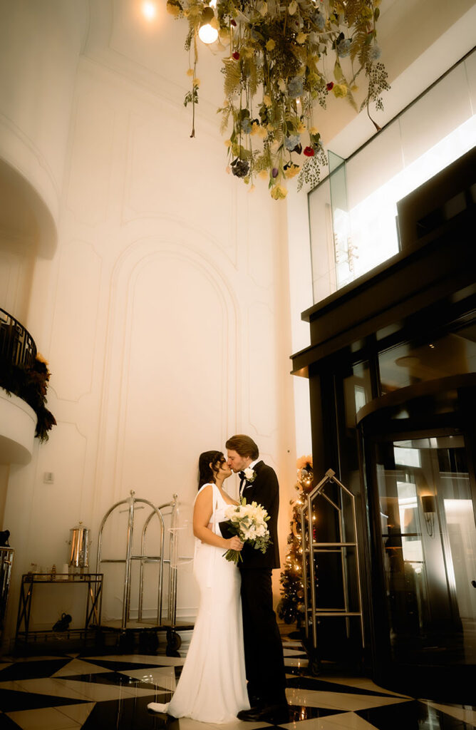 Bride and groom embracing in the colorful decor of the Kimpton Hotel Monaco before their courthouse elopement.