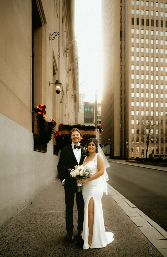 Candid editorial-style moment of Couple standing in Downtown Pittsburgh on their elopement day.