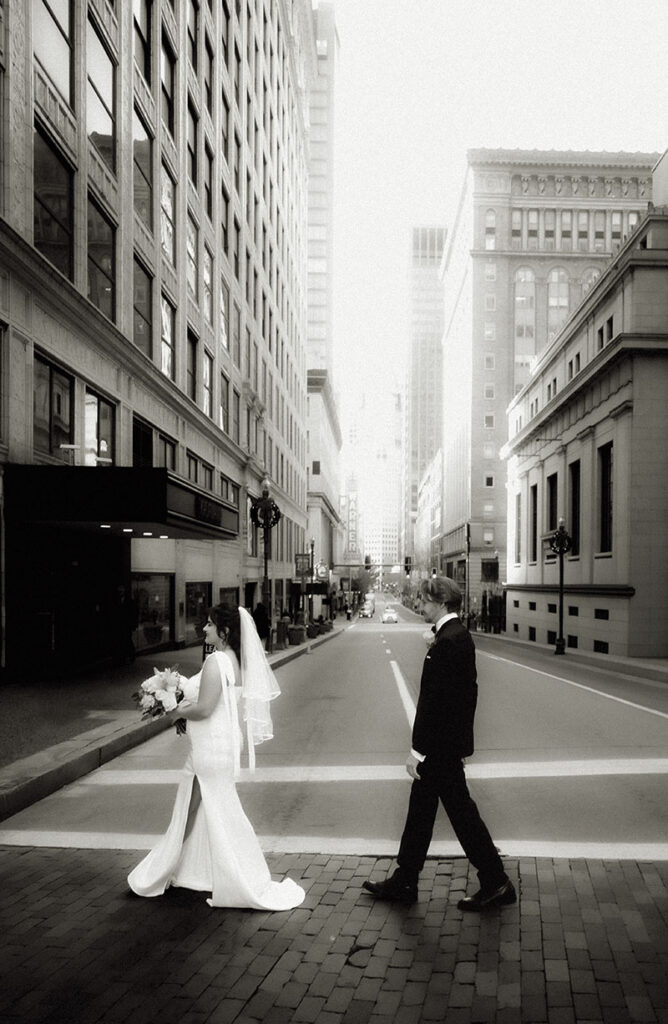 BW Candid editorial-style moment of Aida and Zachery walking through Downtown Pittsburgh on their elopement day.