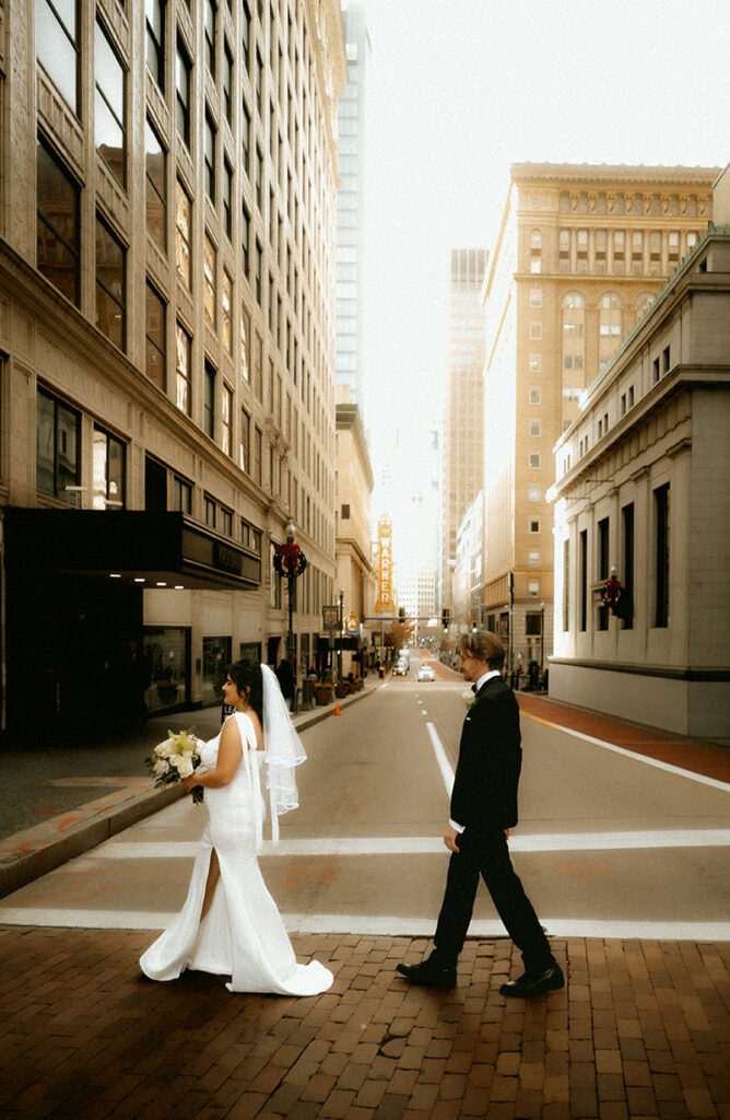 Candid editorial-style moment of Bride and Groom walking through Downtown Pittsburgh on their elopement day.