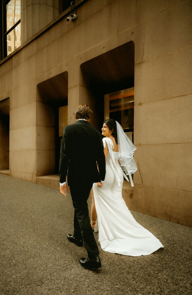 Candid editorial-style moment of Aida and Zachery walking through Downtown Pittsburgh on their elopement day.