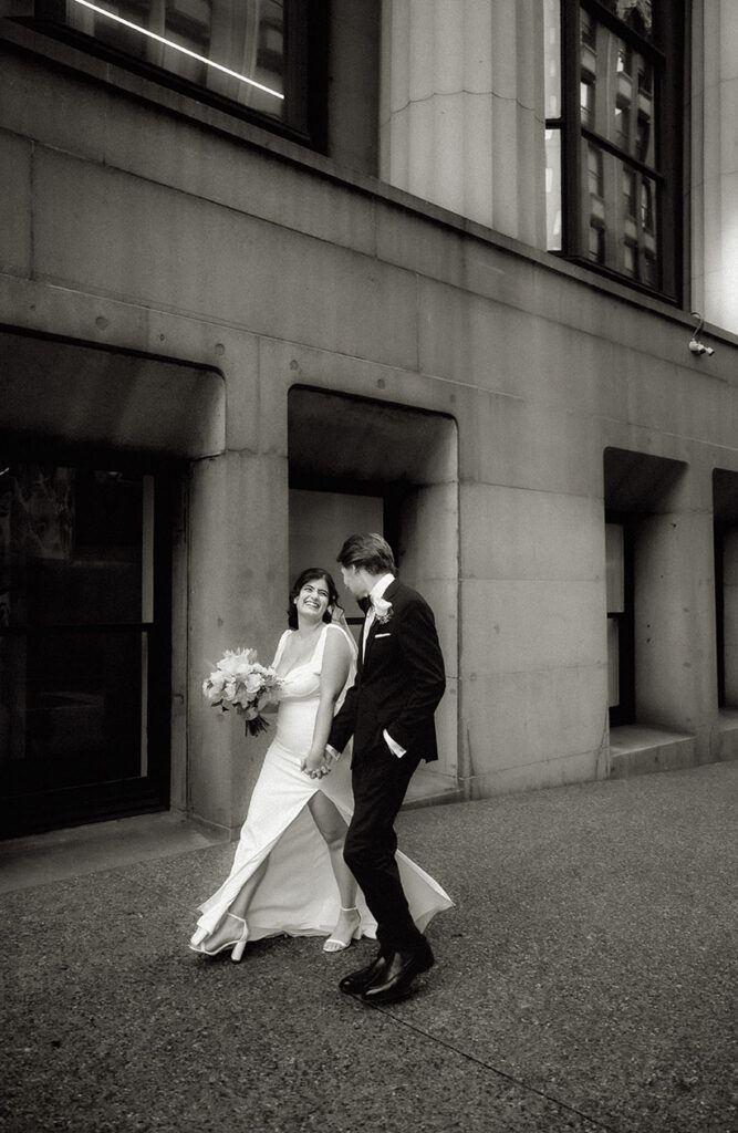 Candid editorial-style moment of Bride and Groom walking through Downtown Pittsburgh on their elopement day.