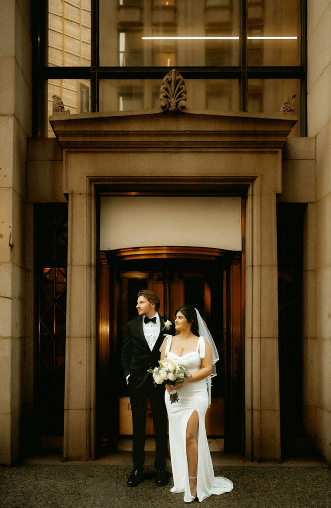 Candid editorial-style moment of couple walking through Downtown Pittsburgh on their elopement day.
