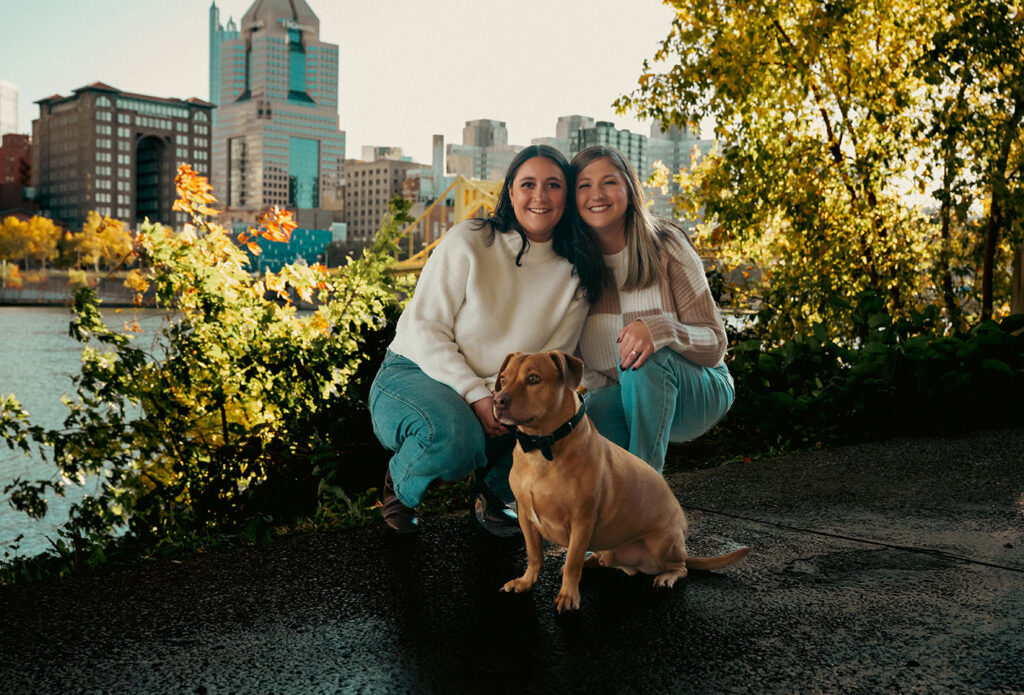 Couple taking sunset photos in Downtown Pittsburgh with their dog during a documentary-style session
