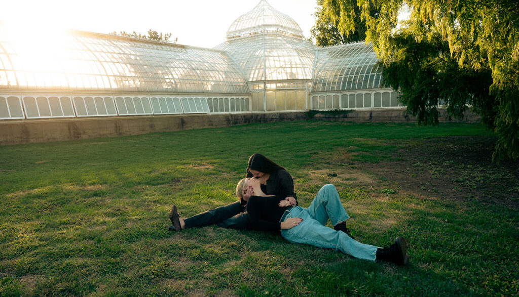 Same Sex Couple laying in the Phipps Garden about to kiss after their wedding engagement