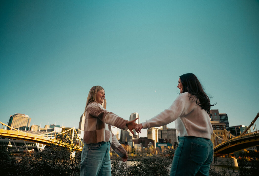 Couple taking sunset photos in Downtown Pittsburgh with their dog during a documentary-style session