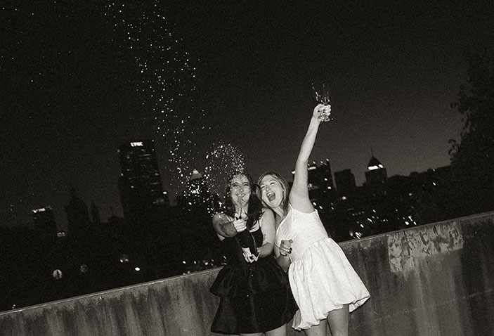 BW Same Sex Couple popping a champagne celebrating their Engagement in the Strip District in Pittsburgh