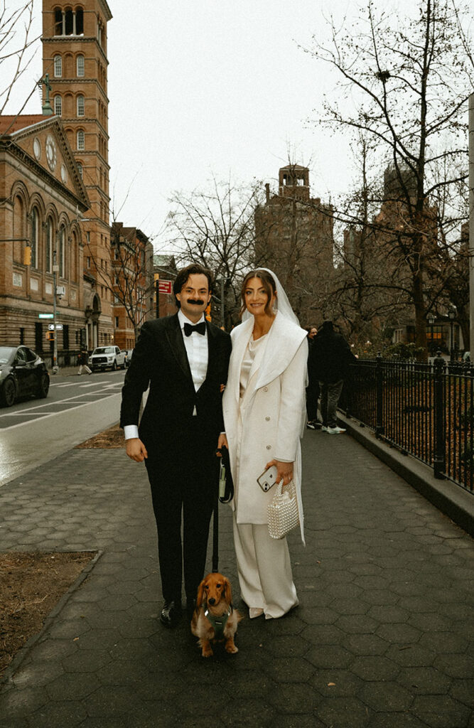 Bride and Groom walking their dog t Washington Square Park during a New York City elopement