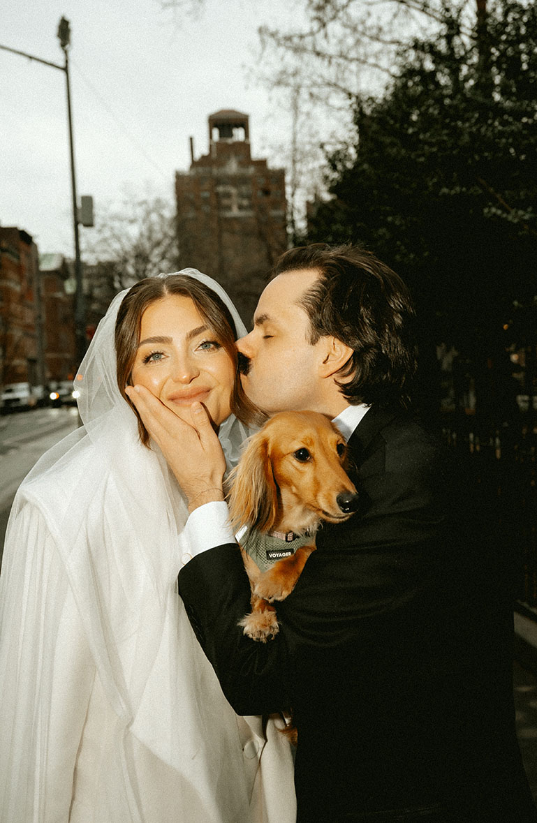 Groom Kisses Bride at Washington Park in NYC with their dog in the middle