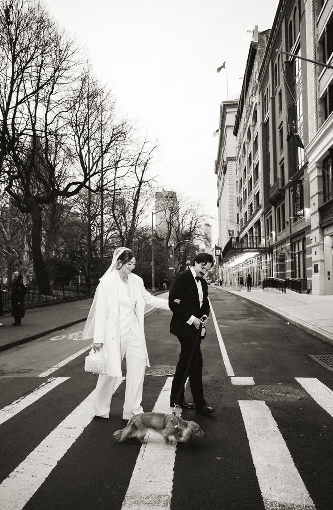 Couple walking through New York City with their dog at Washington Park.
