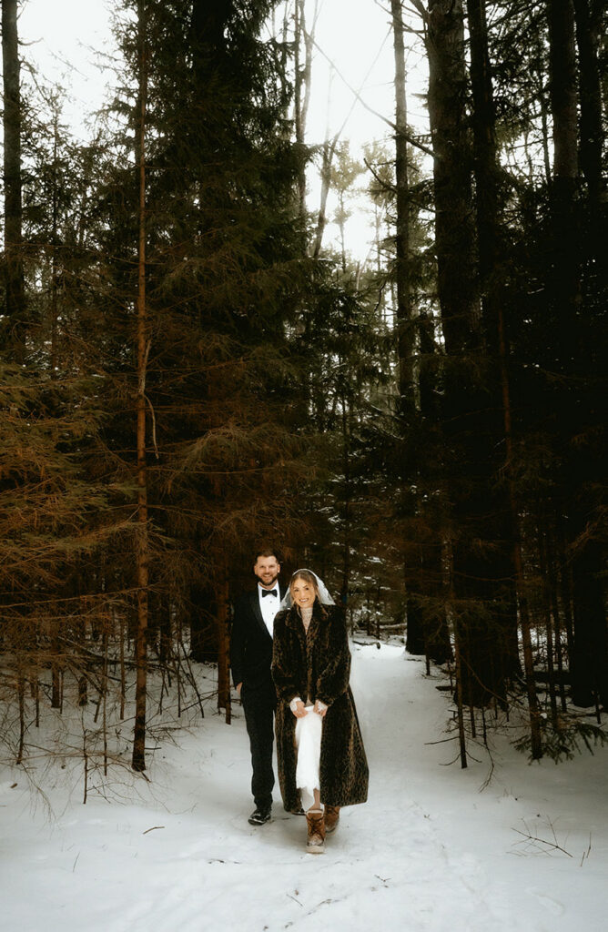 Bride and Groom coming out of the woods after intimate winter ceremony in the Pocono Mountains.