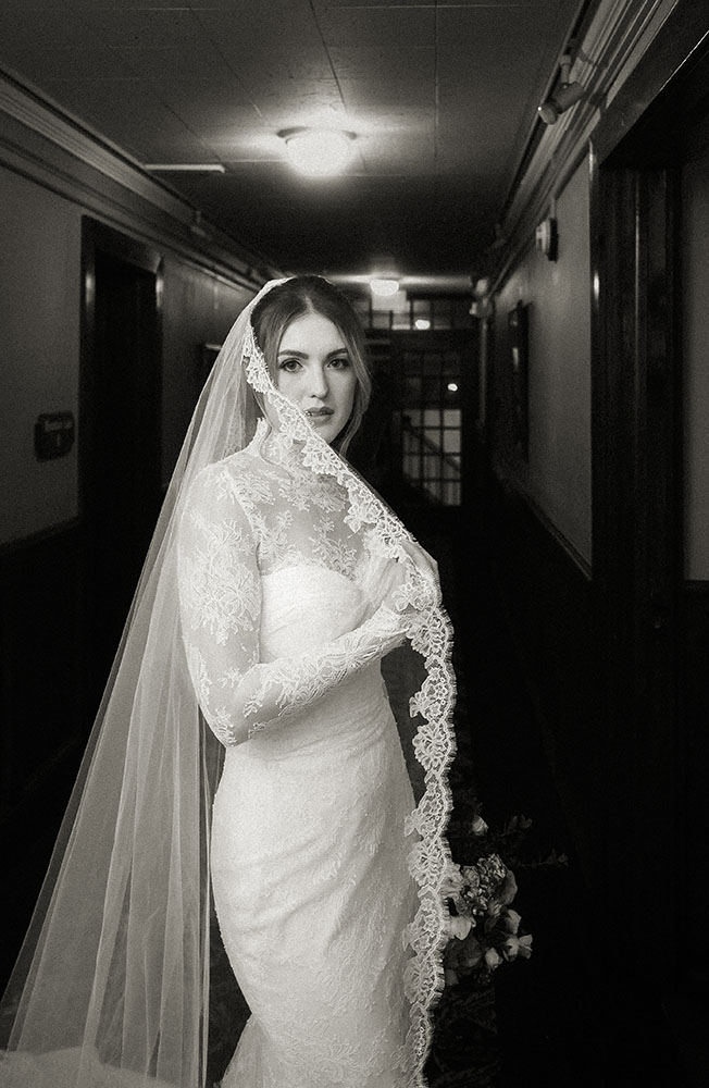 Bride holding bouquet in vintage gown inside Pocono Mountains wedding venue