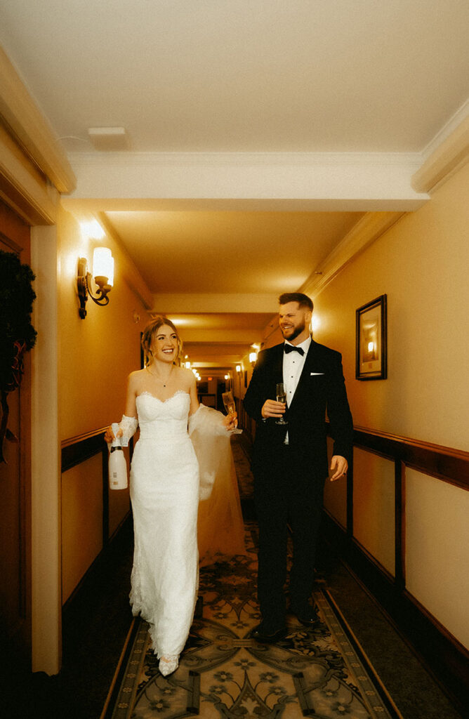 Romantic couple portrait walking while holding champagne inside historic Skytop Lodge Pennsylvania