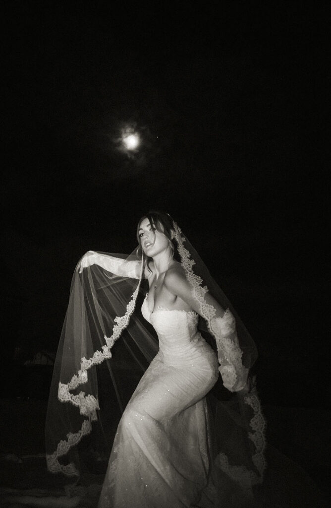 Cinematic night wedding portrait outside Skytop Lodge under January full moon