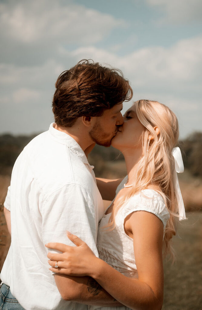 Couple Kiss during their romantic engagement session in Pittsburgh Summer Scenery.
