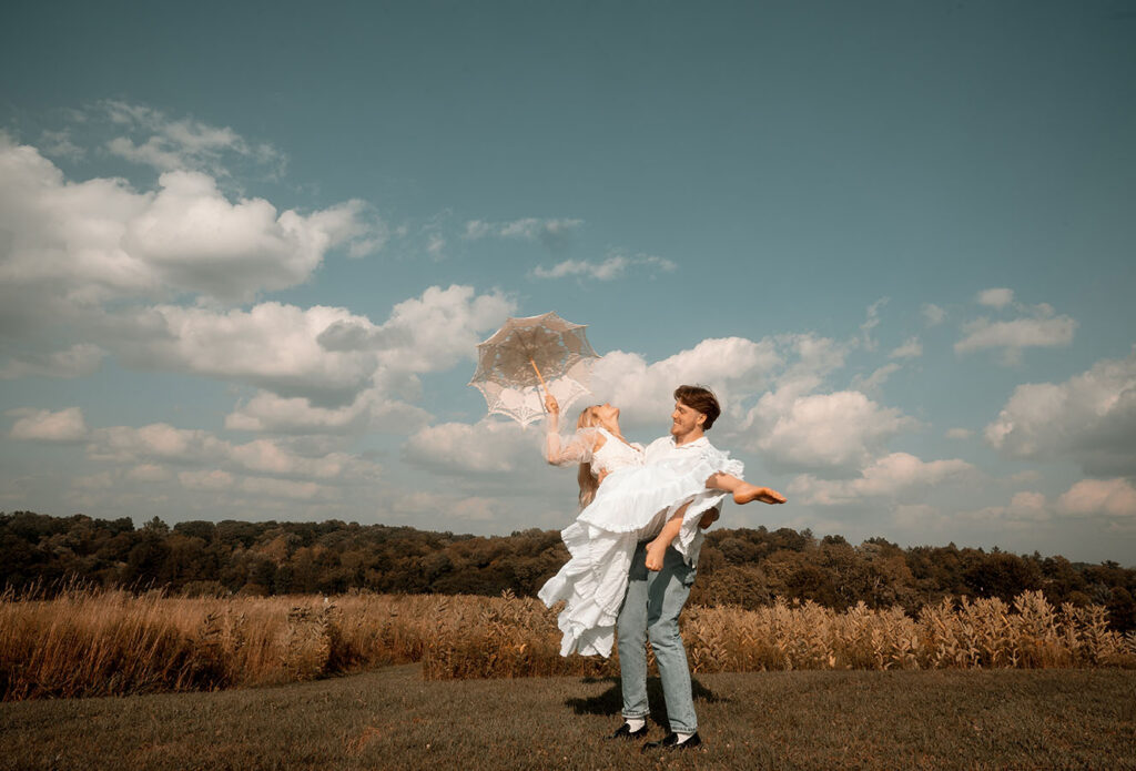 Wide cinematic engagement photo in Pittsburgh showing couple surrounded by summer greenery