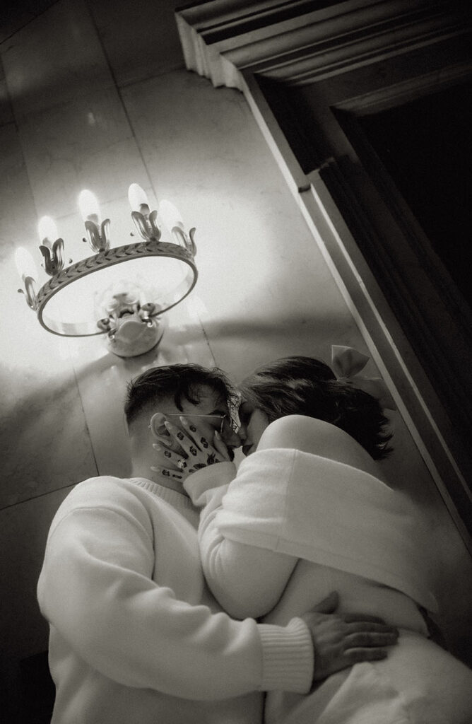 BW Elegant engagement portrait in Carnegie Museum showing couple seated on steps with refined editorial energy