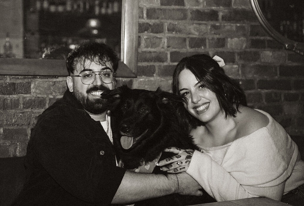 BW Romantic Pittsburgh engagement portrait with couple holding their dog in meaningful South Side location