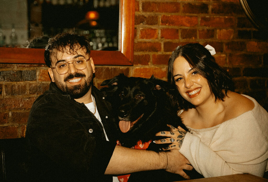 Romantic Pittsburgh engagement portrait with couple holding their dog in meaningful South Side location.