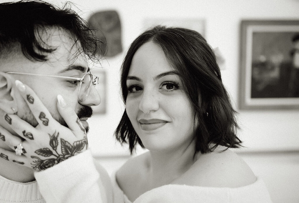 Artistic engagement photo in Pittsburgh museum with couple interacting naturally beside historic artwork