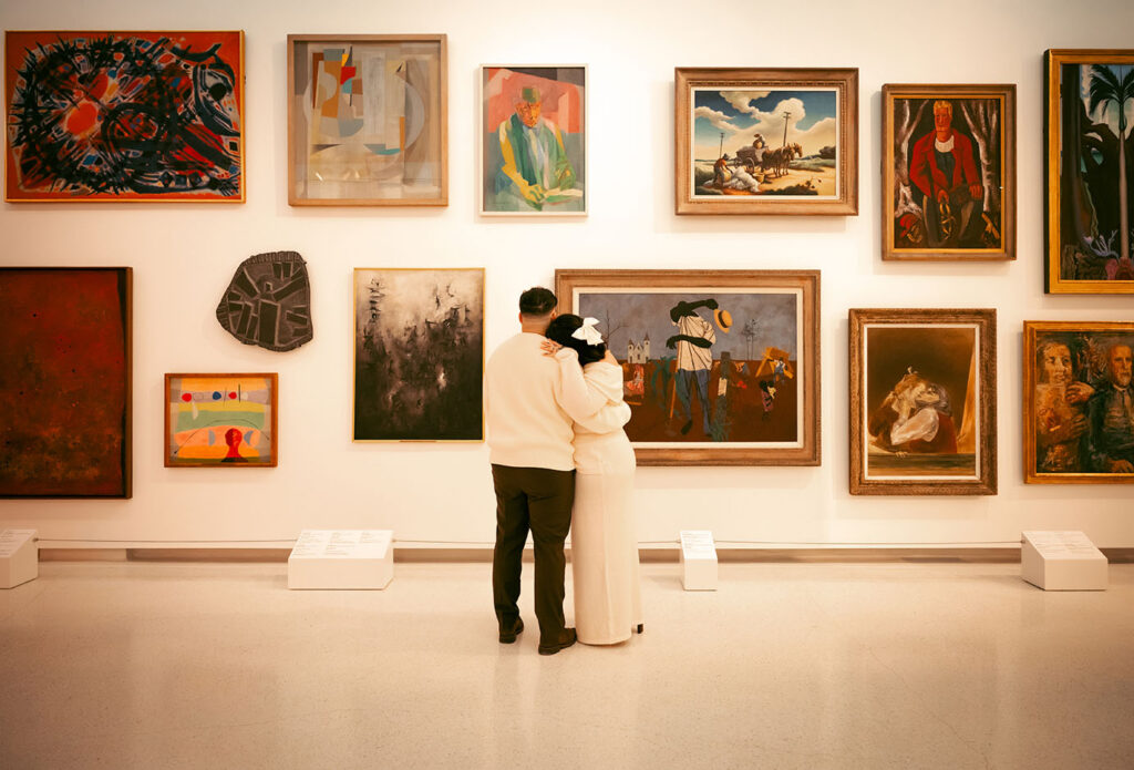 Romantic engagement portrait in Carnegie Museum of Art Pittsburgh framed by artwork and architectural columns