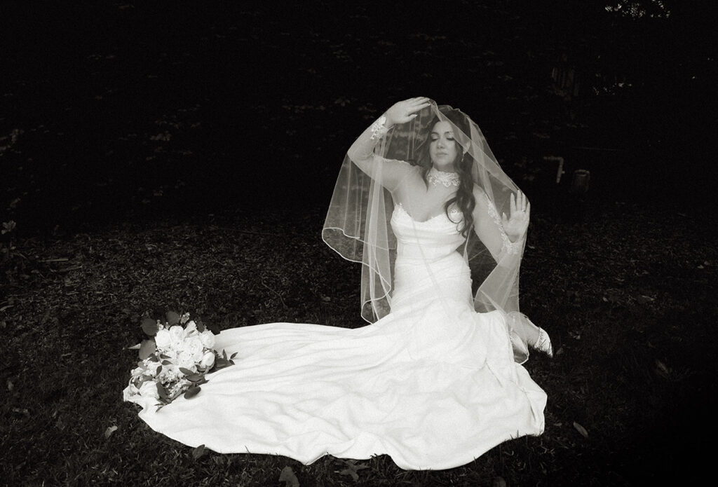 Bride standing in natural window light wearing a classic wedding dress.