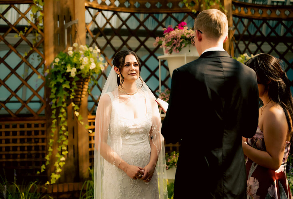 Bride holding a pink-and-white bouquet in the sunlit gardens at Phipps Conservatory.