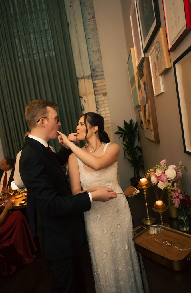 Bride playfully feeding the groom dessert during their candlelit Balvanera wedding reception.
